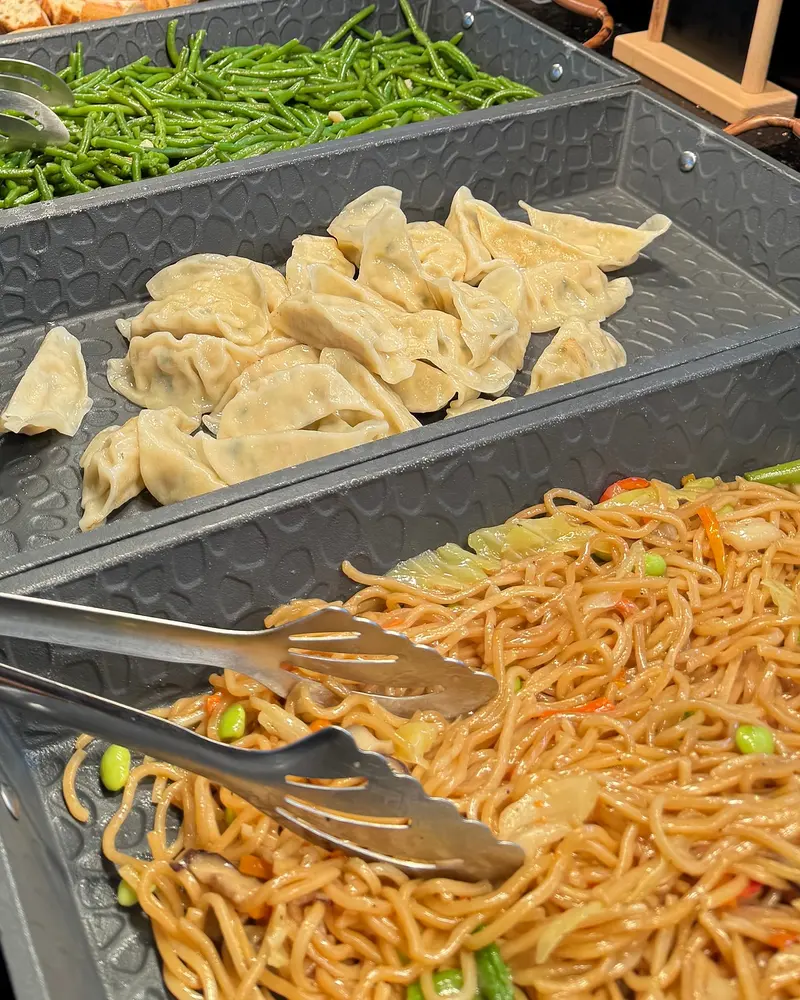 Plats chauds au buffet : gyozas grillés et nouilles sautées aux légumes