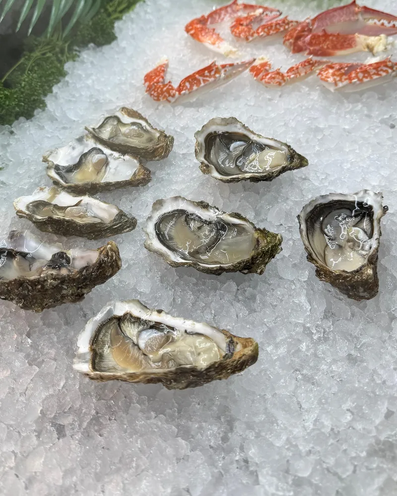 Huîtres ouvertes sur glace pilée, pinces de crabe derrière